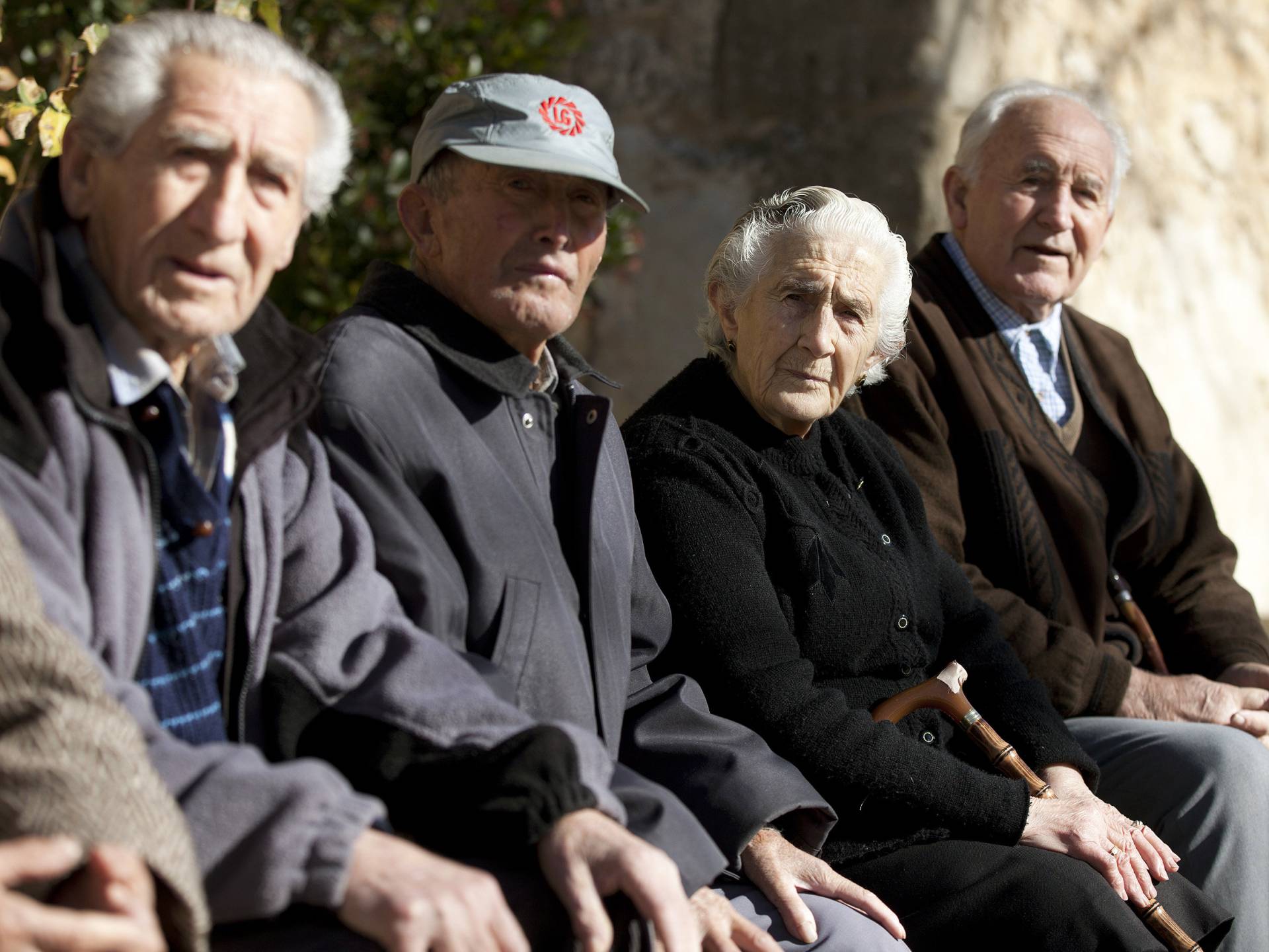 Ancianos sentados en una plaza pública.