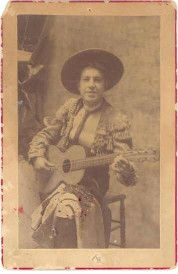 Retrato de estudio de Joaquín Sorolla joven. Viste de torero con sombrero cordobés y aparece sentado en un taburete alto tocando la guitarra.