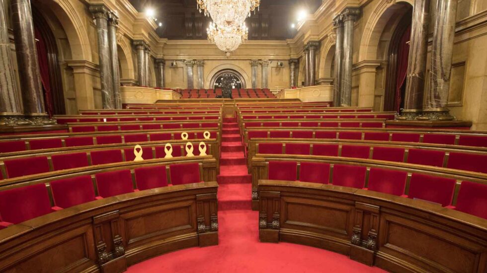 El Parlament de Cataluña, vacío y con los lazos amarillos en los escaños de los diputados huidos y encarcelados.