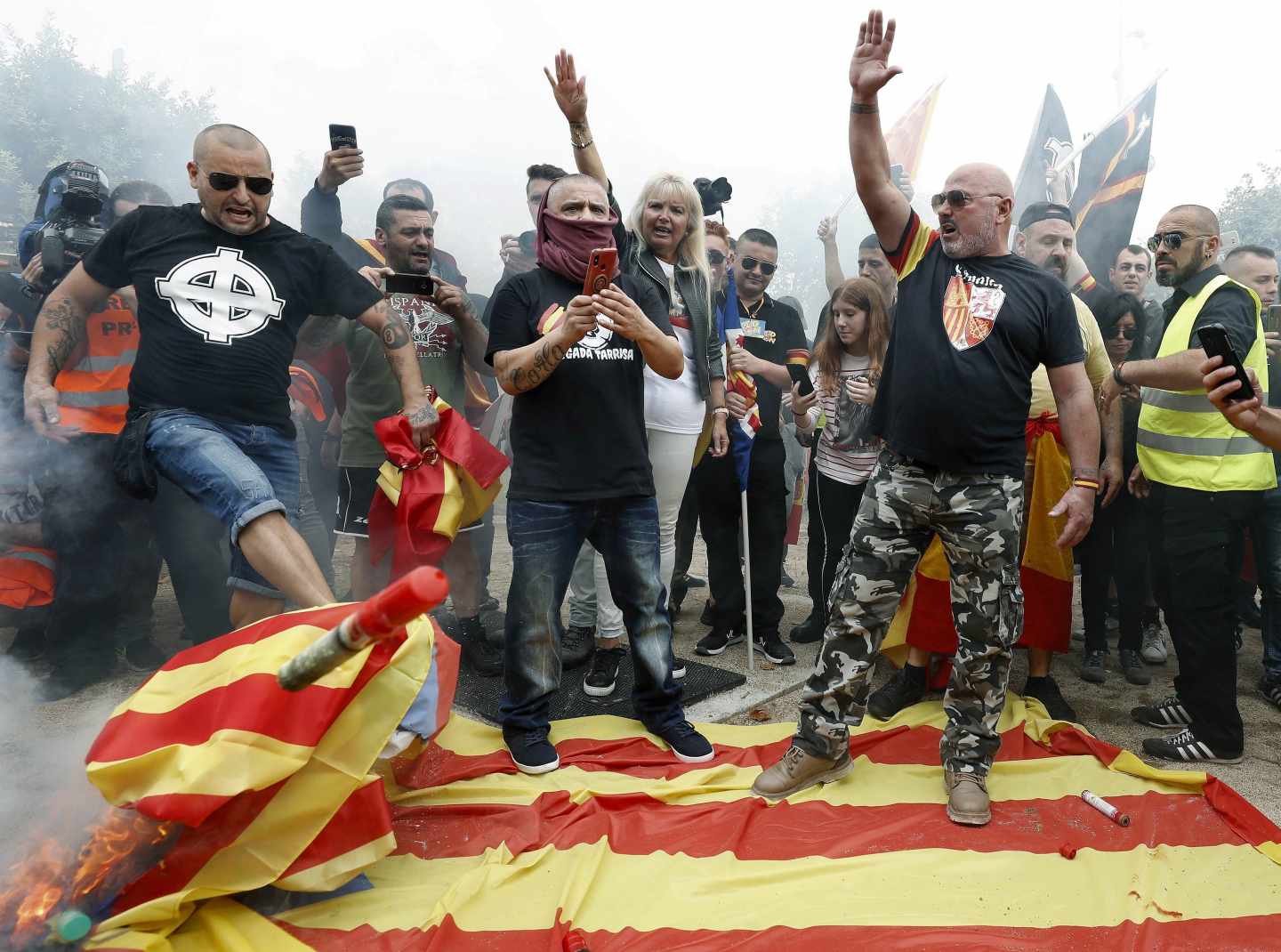 Manifestantes en Montjuic queman banderas independentistas catalanas.