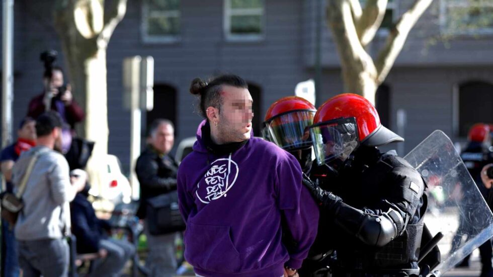 Un joven es detenido por agentes de la Ertzaintza durante la concentración que un centenar de personas han llevado a cabo ante el Palacio Euskalduna de Bilbao, donde esta tarde participa el líder de Vox, Santiago Abascal en un acto electoral.