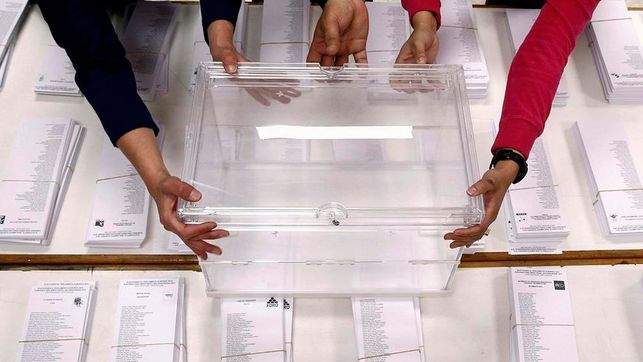 Una urna junto a papeletas en una jornada de elecciones.
