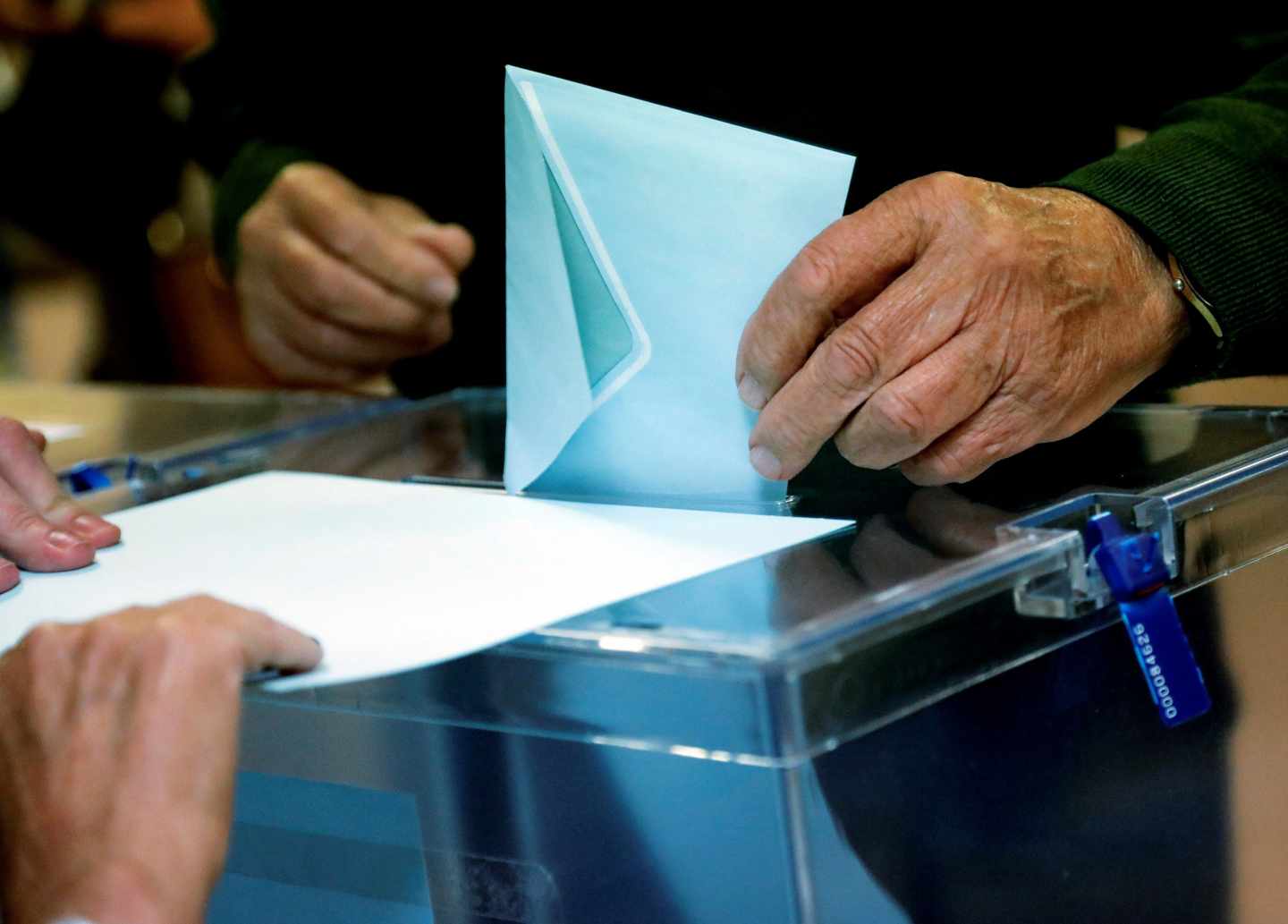 Un ciudadano deposita su voto ante la urna en Madrid.