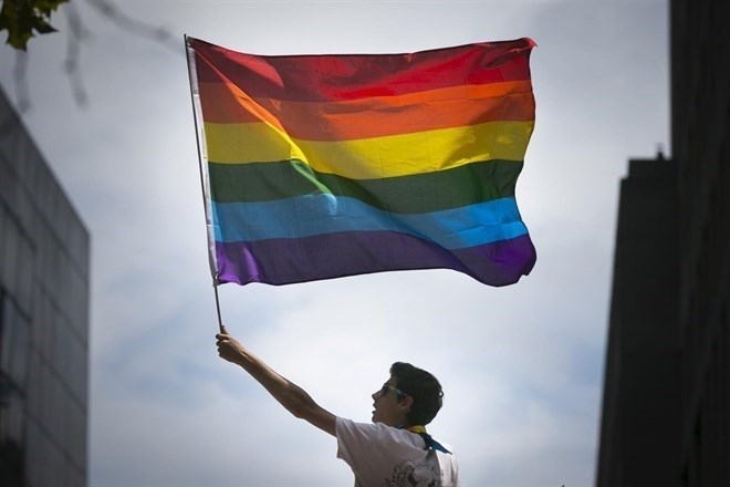 Joven portando la bandera del Orgullo LGTBI.