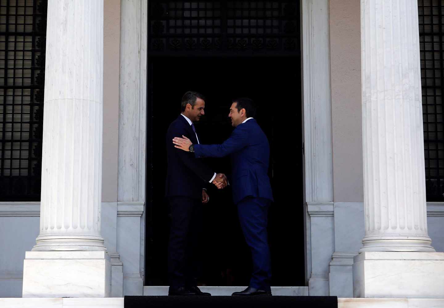 Kyriakos Mitsotakis, izqda, primer ministro de Grecia, y el jefe del gobierno saliente, Alexis Tsipras, se dan la mano en el Palacio Presidencial de Atenas.