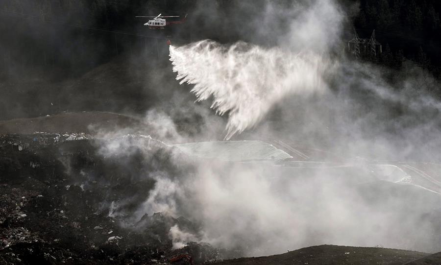 Un helicóptero arroja agua sobre un incendio ocasionado en el vertedero de Zaldibar.