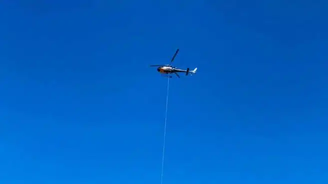Un helicóptero lanza espuma sellante sobre el vertedero de Zaldibar para controlar los fuegos