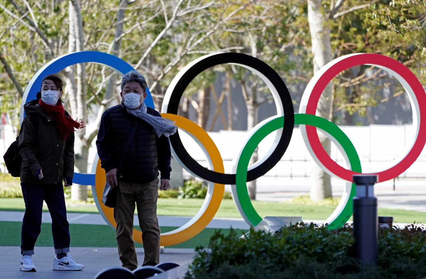 Dos personas con mascarilla caminan en la entrad del Comité Olímpico de Japón