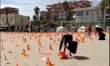 Militantes del Frente Obrero arrancan las banderas por las víctimas del Covid de la playa de Valencia