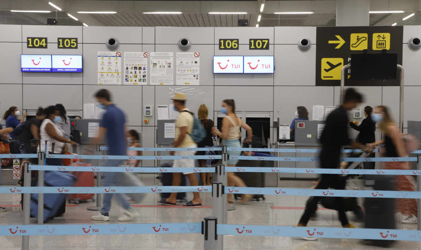 Varios pasajeros hacen cola en los mostradores de facturación de Tui en el aeropuerto de Palma de Mallorca, en una imagen de archivo.