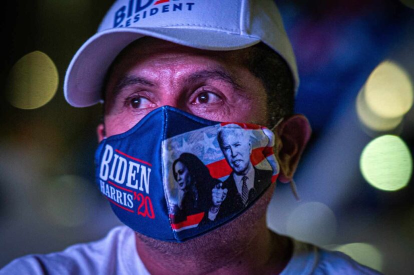 Un latino sigue el recuento de la votación con una mascarilla de Joe Biden y Kamala Harris en Miami
