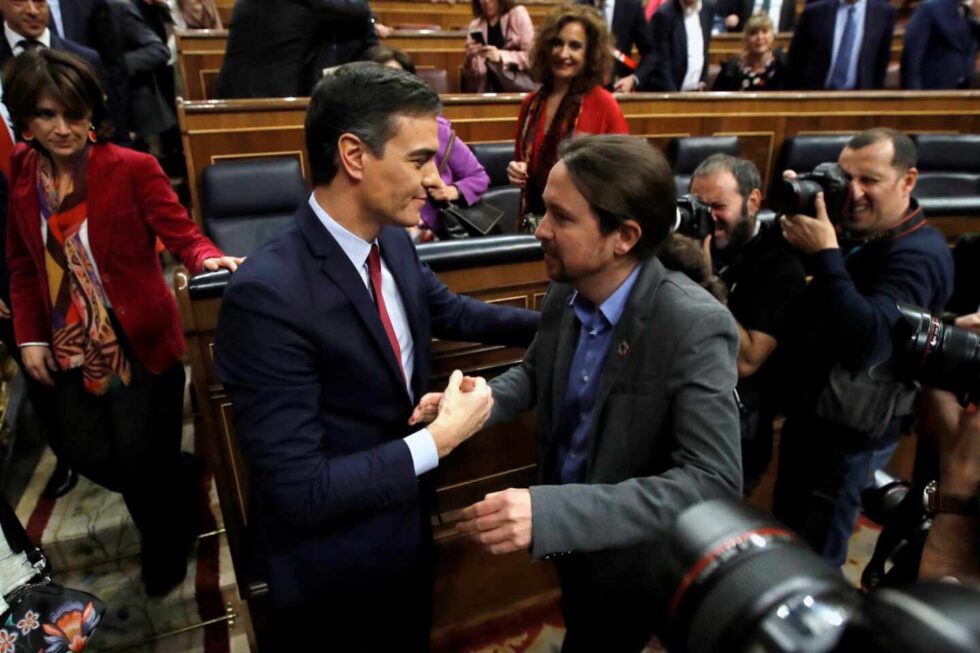 Pablo Iglesias y Pedro Sánchez se felicitan después de conseguir los apoyos para formar el Gobierno de Coalición.