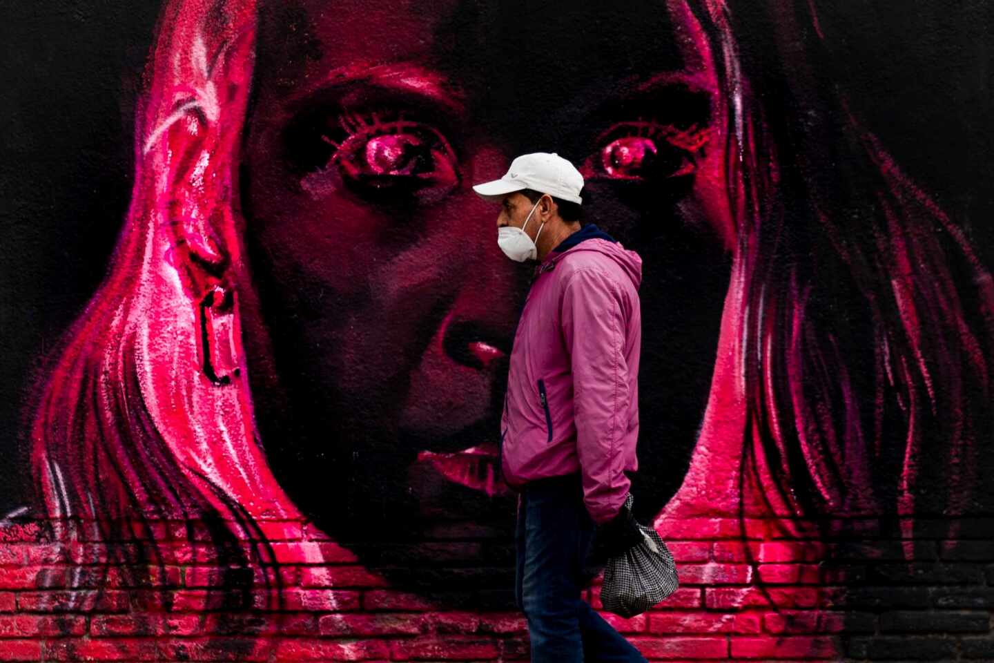 Una persona pasa frente a un grafitti este lunes en Barcelona