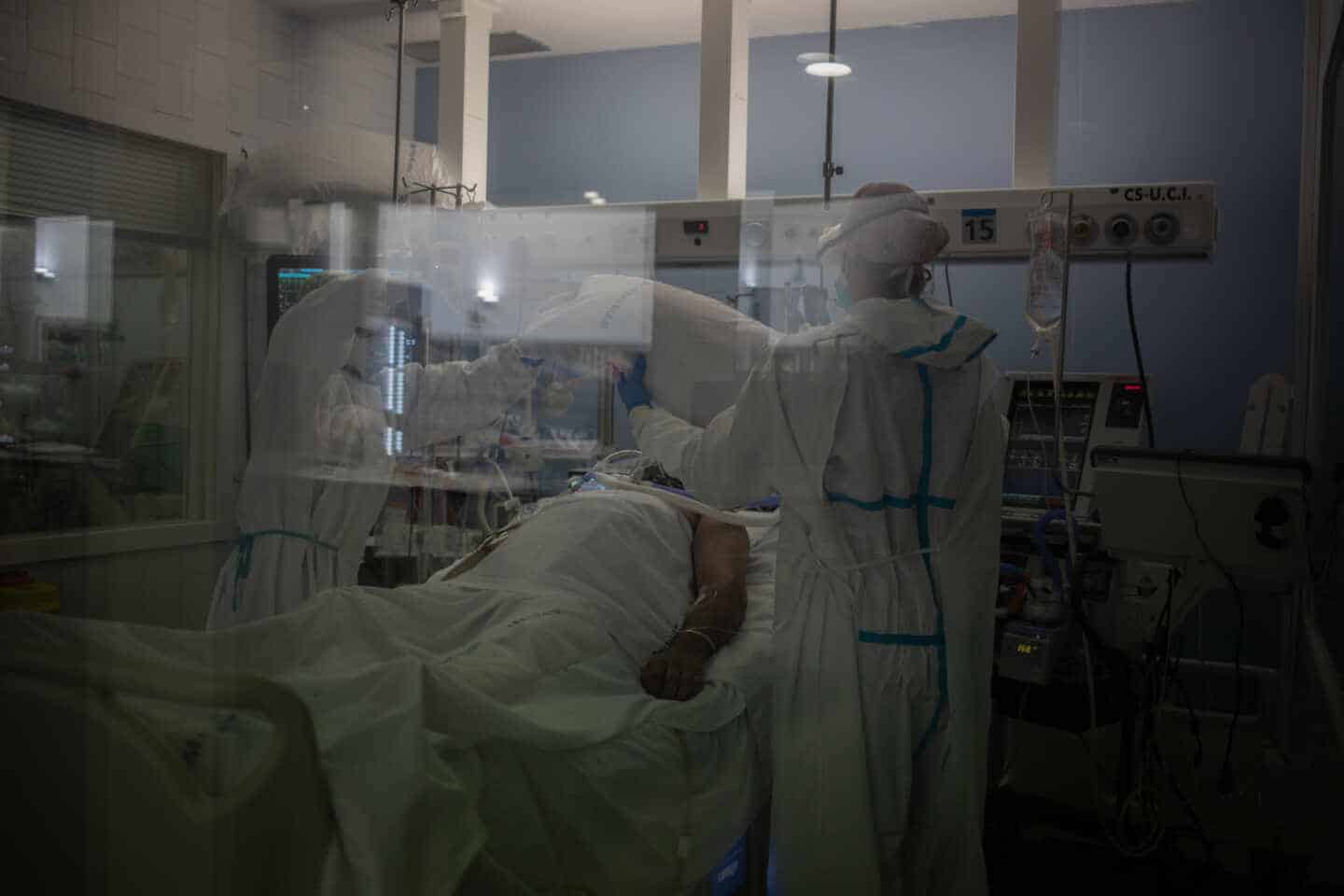 Trabajadores sanitarios atienden a un paciente en la UCI del Hospital del Mar, en Barcelona.