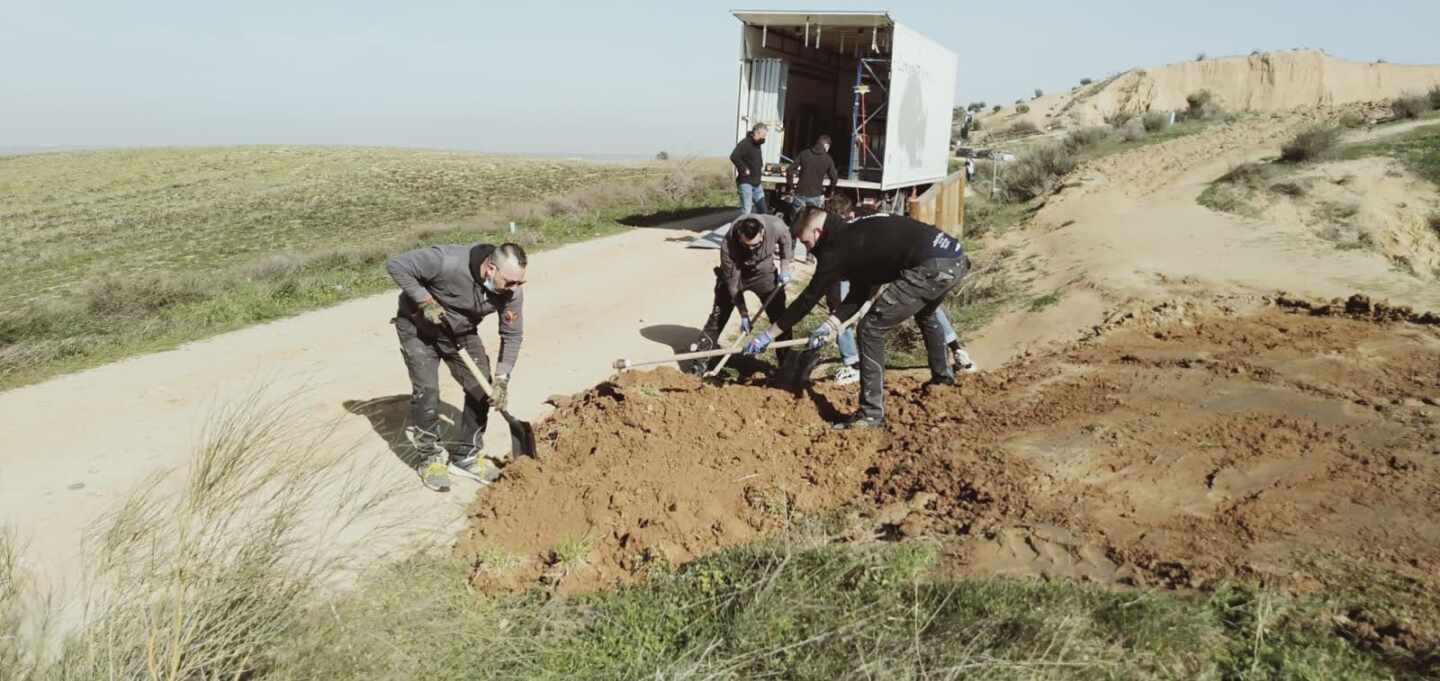 Trabajadores de producción con material de excavación en sus manos en un terreno