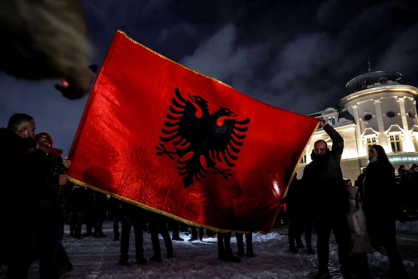 Un grupo de seguidores de Vetvendosje celebran la victoria electoral con una gran bandera de Kosovo, en Pristina
