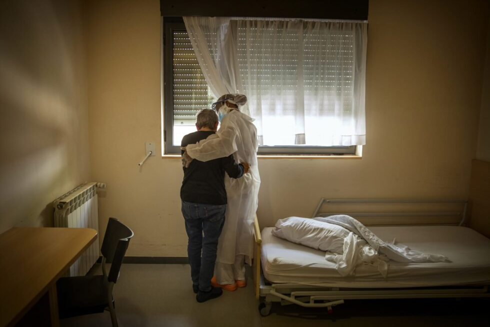 Una enfermera de una residencia de ancianos atiende a un mayor en su dormitorio