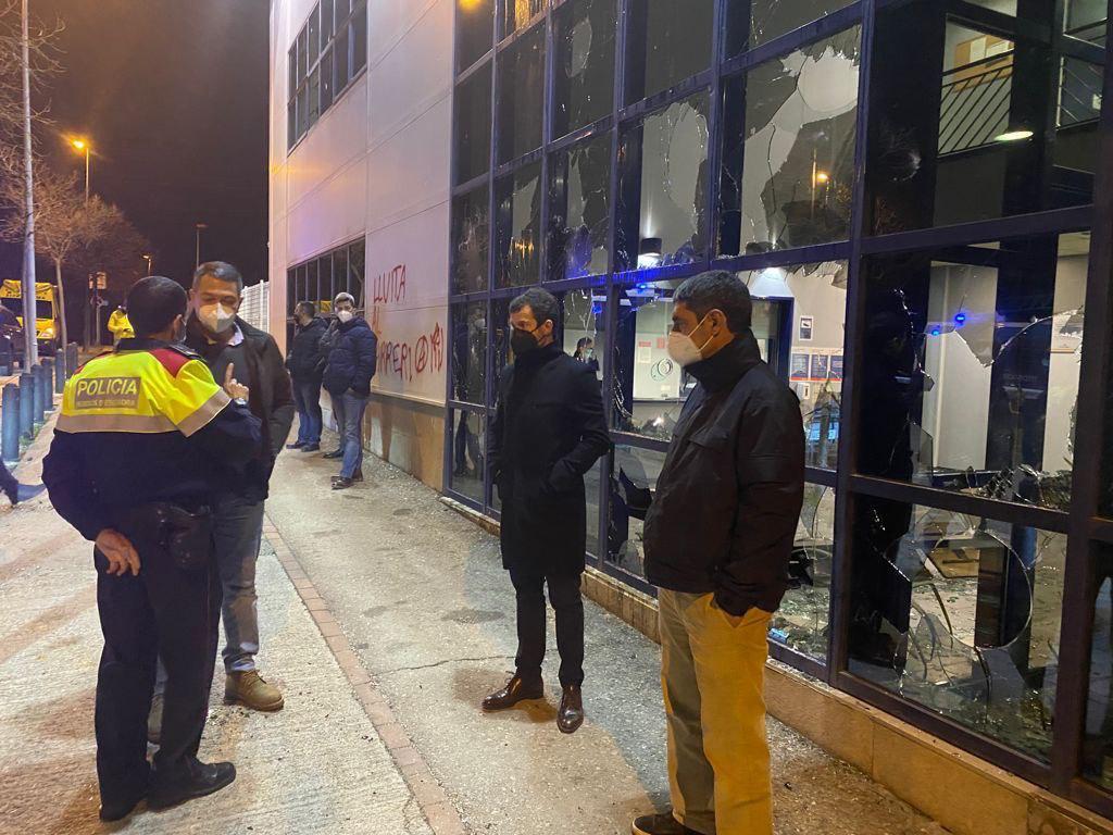 El consejero de Interior de la Generalitat, Miquel Sàmper, habla con un agente de policía frente a las cristaleras destrozadas de la Comisaría de los Mossos en Vic durante las protestas por la detención del rapero Pablo Hasel.