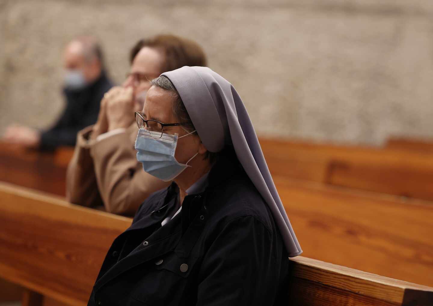 Una monja reza durante la celebración de la Santa Eucaristía en la Parroquia de Santa Elena, en Madrid.