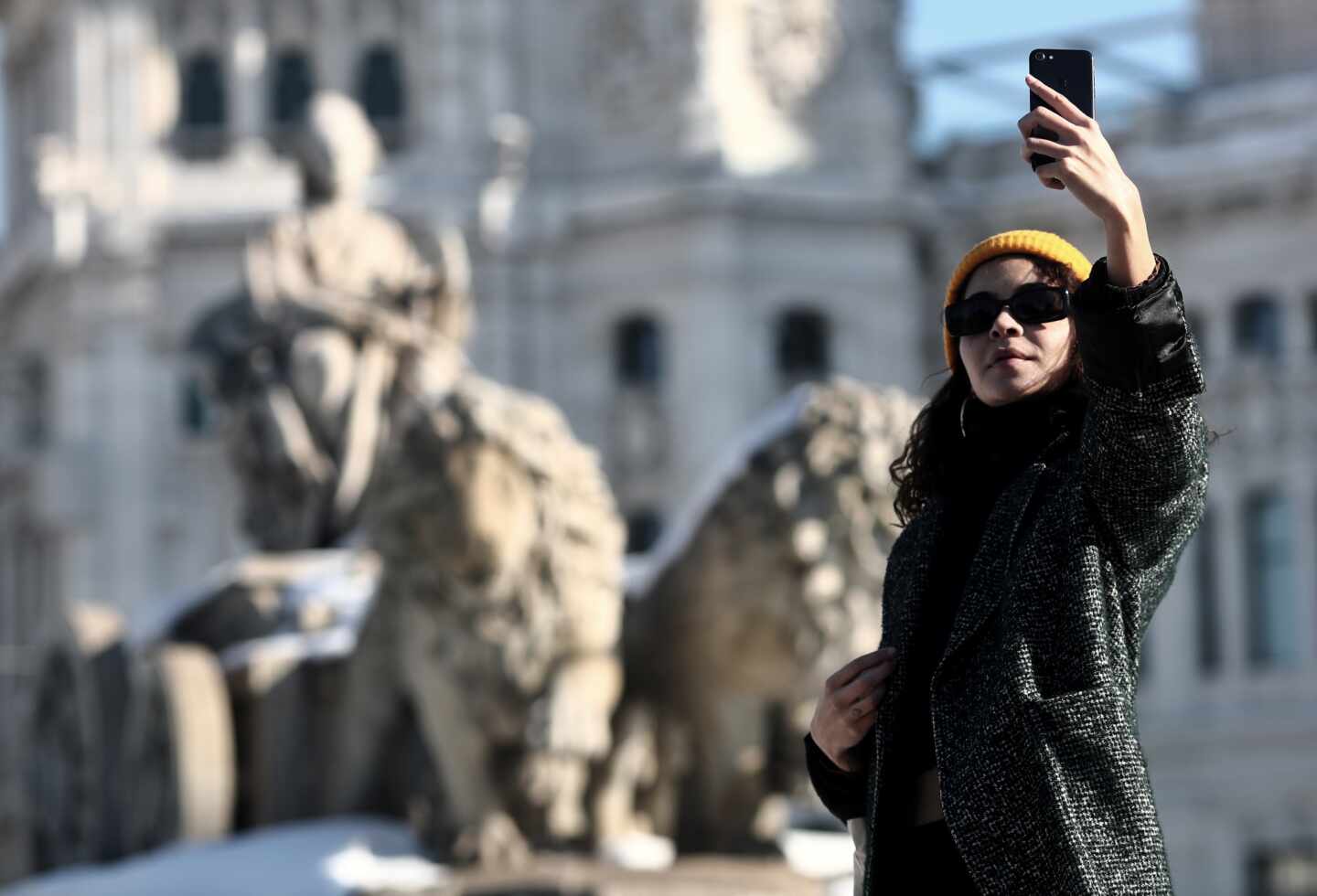 Una mujer se hace un selfie junto a la estatua de Cibeles en Madrid.