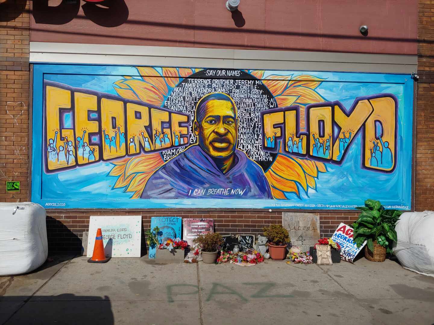 Un gran cartel con la imagen de George Floyd con flores en su recuerdo en Minneapolis