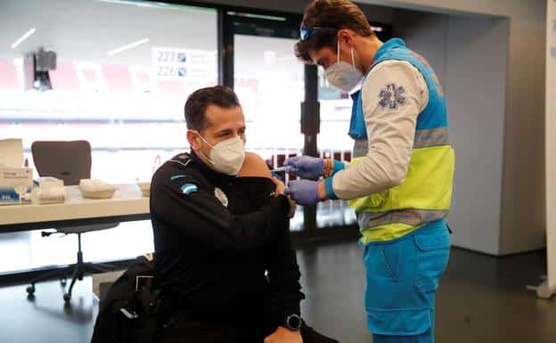 Un policía recibe una dosis de la vacuna de AstraZeneca en el estadio Wanda Metropolitano
