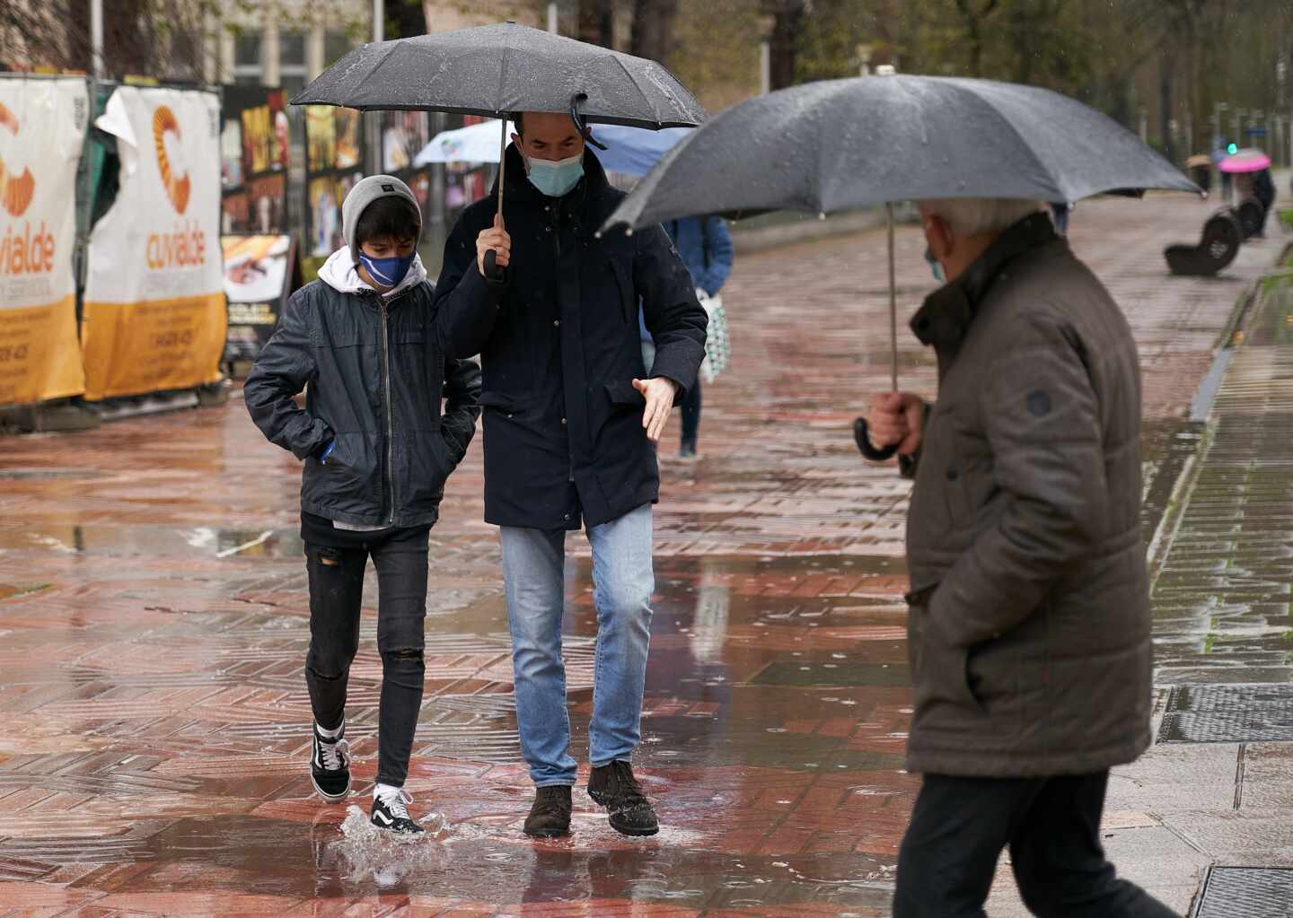 Varias personas se refugian con un paraguas de la lluvia en Vitoria, País Vasco