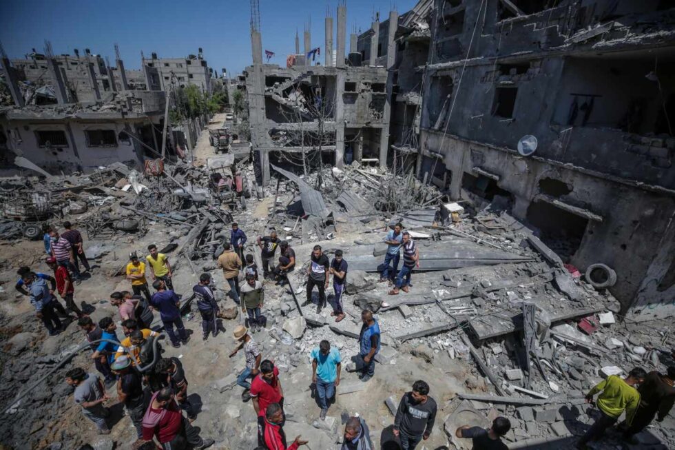 Varios palestinos inspeccionan los restos de un edificio destrozado tras los ataques
