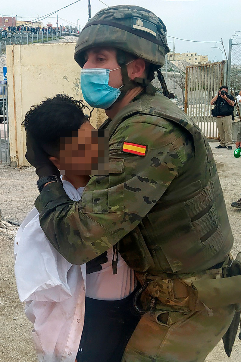 Un militar ayuda a un joven inmigrante tras su llegada a España