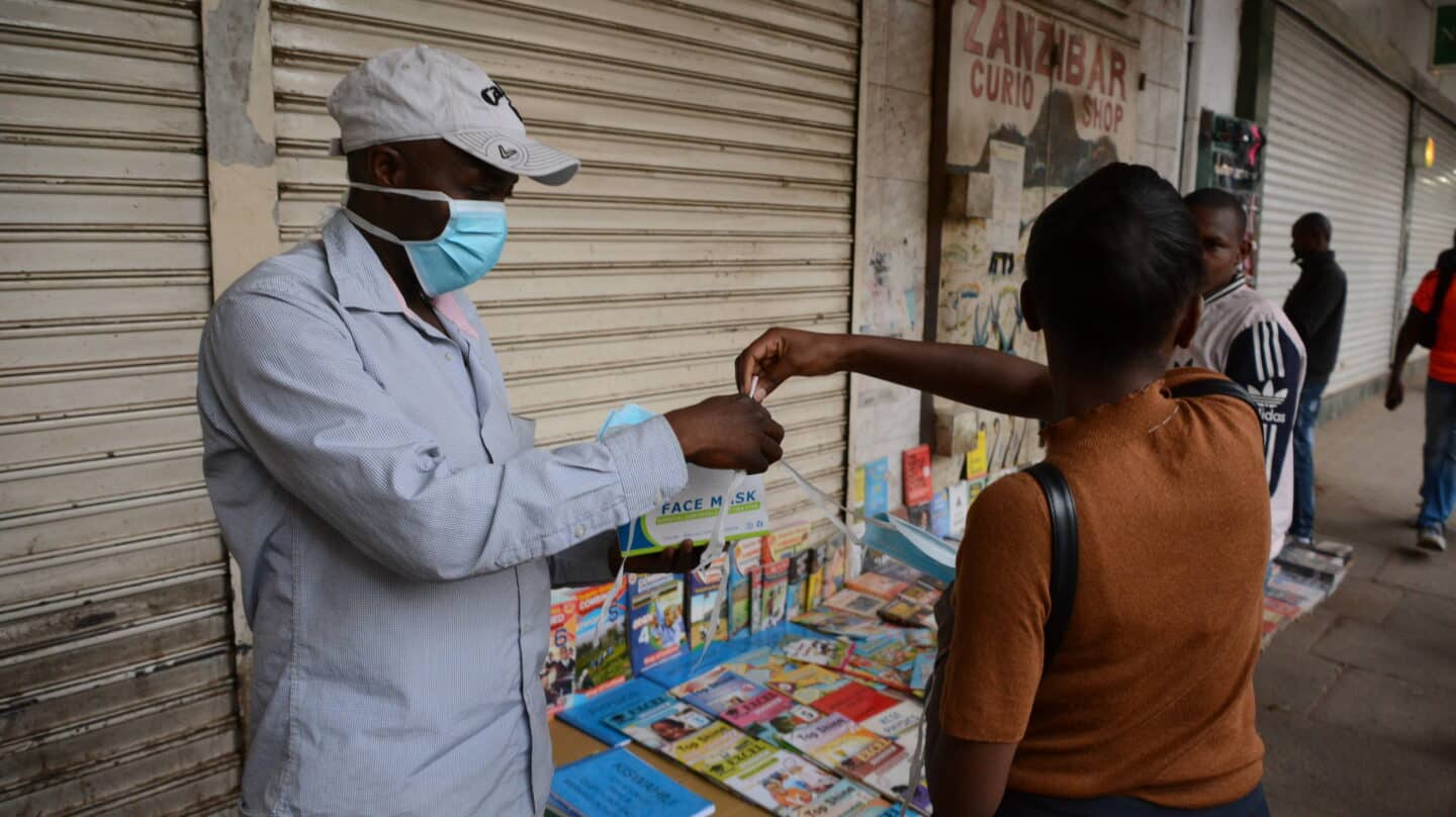 Una mujer compra una mascarilla en una calle de Nairobi, Kenia.