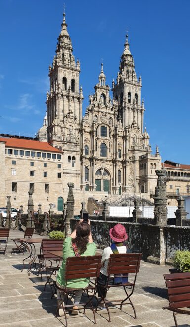 Dos turistas toman algo en una terraza en la plaza del Obradoiro