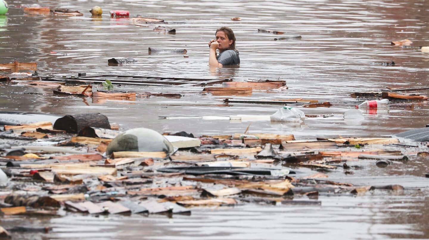 una mujer atraviesa una calle inundada en belgica