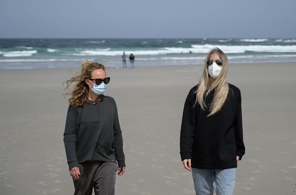 Dos mujeres con mascarilla en una playa de A Coruña.