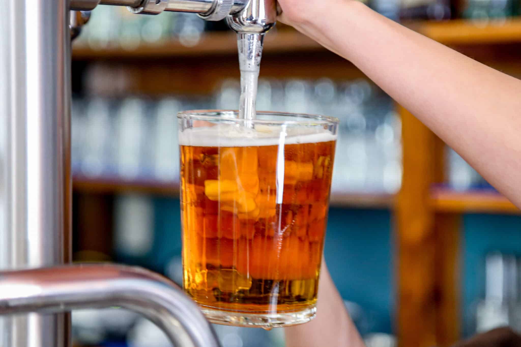 Un camarero tira una cerveza en un bar.