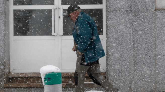 Man walking in the cold weather of Spain on a snowy street in Pedrafita do Cebreiro, Lugo, Galicia