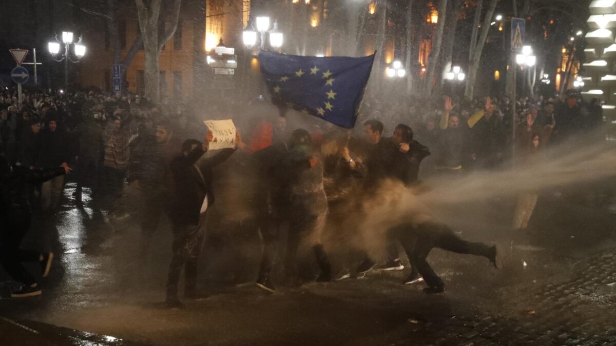 Manifestantes reciben el golpe de un cañón de agua, este martes en Tbilisi.