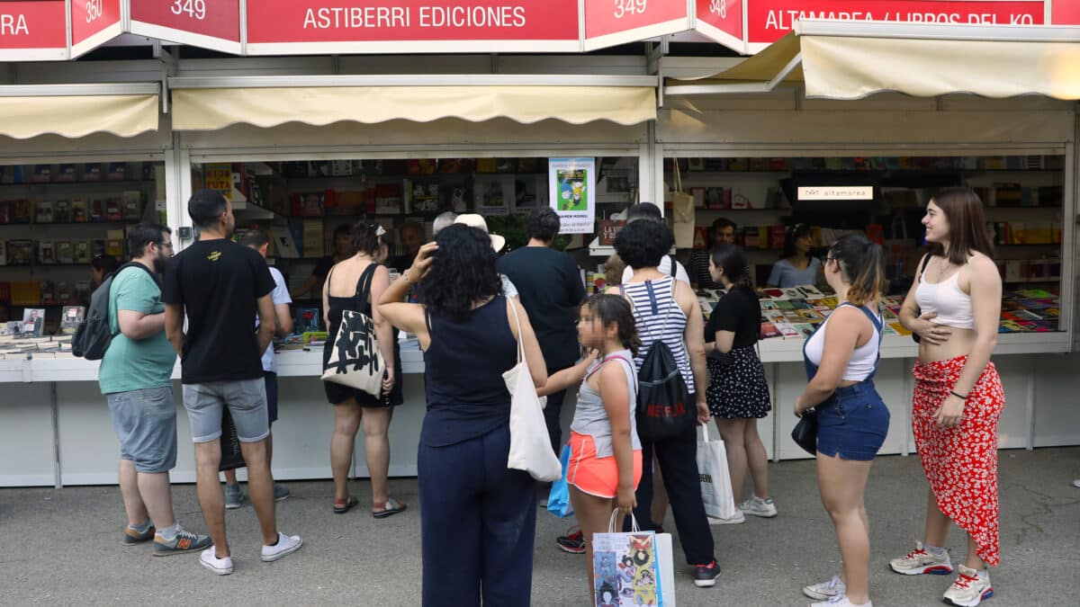 Varias personas visitan la caseta de Astiberri Ediciones en la Feria del Libro 2022