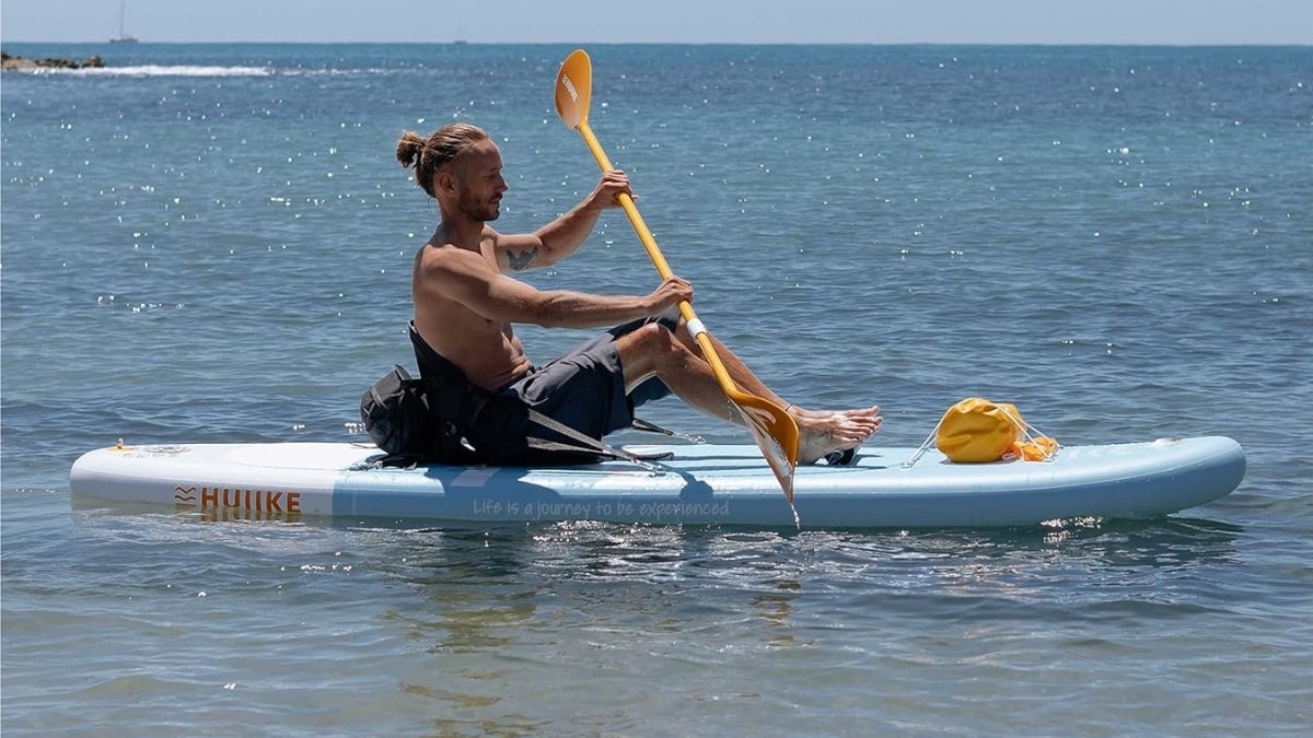 Hombre sobre tabla paddle surf en el mar