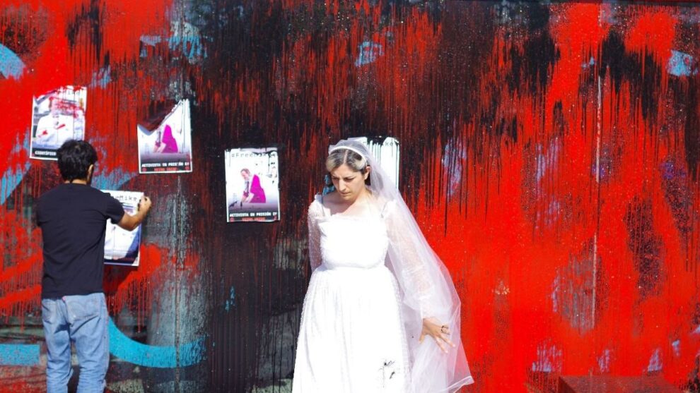 La activista Elena González, que ha pintado la fachada de la embajada británica vestida de novia para protestar por el encarcelamiento de su novio, también activista, en Reino Unido
