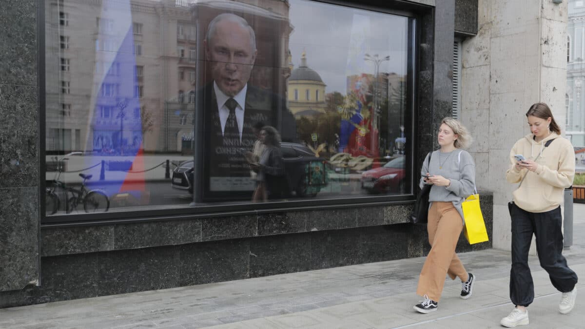 La imagen de Putin se refleja en un escaparate en Moscú