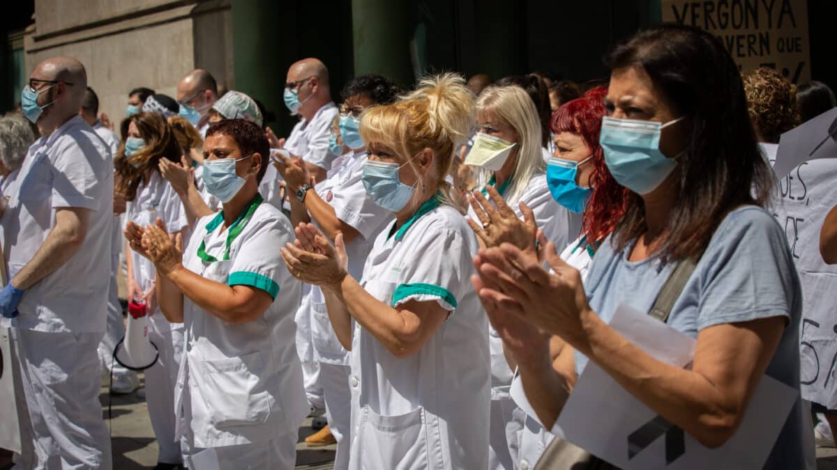 Varias trabajadoras protegidas con mascarilla se reúnen a las puertas del Hospital Clínic de Barcelona