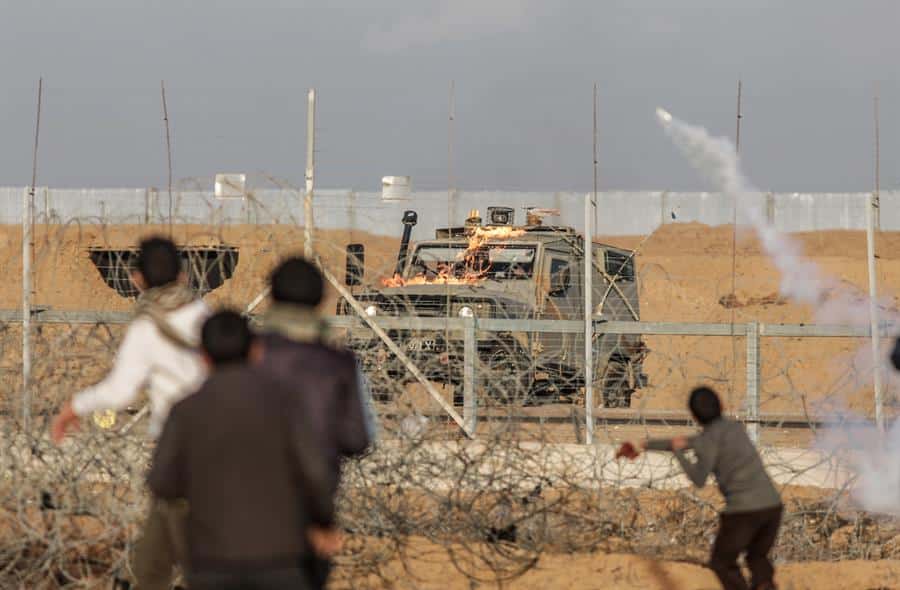 Varios manifestantes palestinos devuelven granadas de gas lacrimógeno a las fuerzas israelíes durante un enfrentamiento en la frontera entre Israel y la Franja de Gaza (Palestina) en 2019.