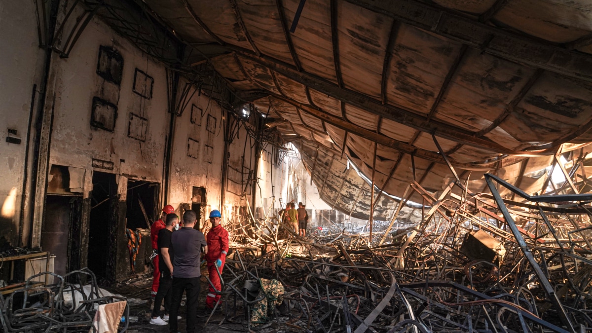 Miembros de los equipos de rescate en el salón de bodas incendiado en el norte de Irak.