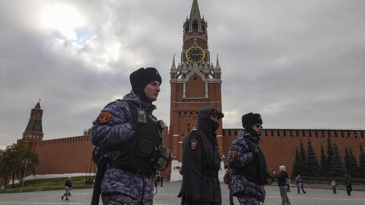 Los policías rusos están cubiertos con ropa abrigada por el viento frío y la baja temperatura mientras caminan frente a la Torre Spaskaya en la Plaza Roja de Moscú