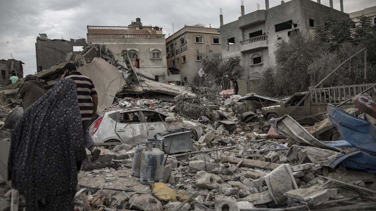 Palestinos buscan cuerpos y supervivientes entre los escombros de un edificio residencial tras un ataque israelí en Khan Younis, sur de la Franja de Gaza, 12 de noviembre de 2023.