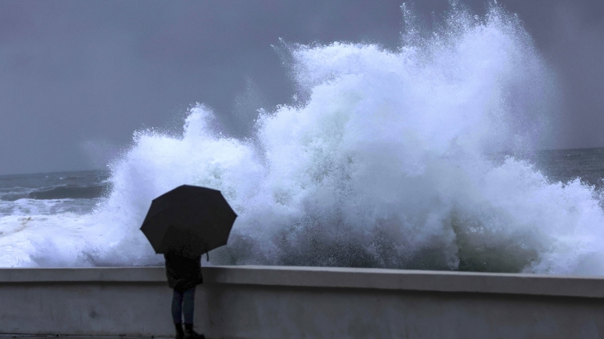 Una persona observa como rompe el fuerte oleaje de este viernes en la costa de Baiona (Pontevedra)