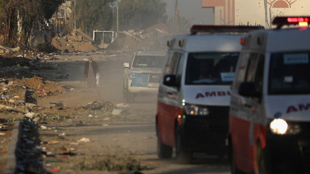 Un anciano palestino camina detrás de ambulancias palestinas que transportan heridos