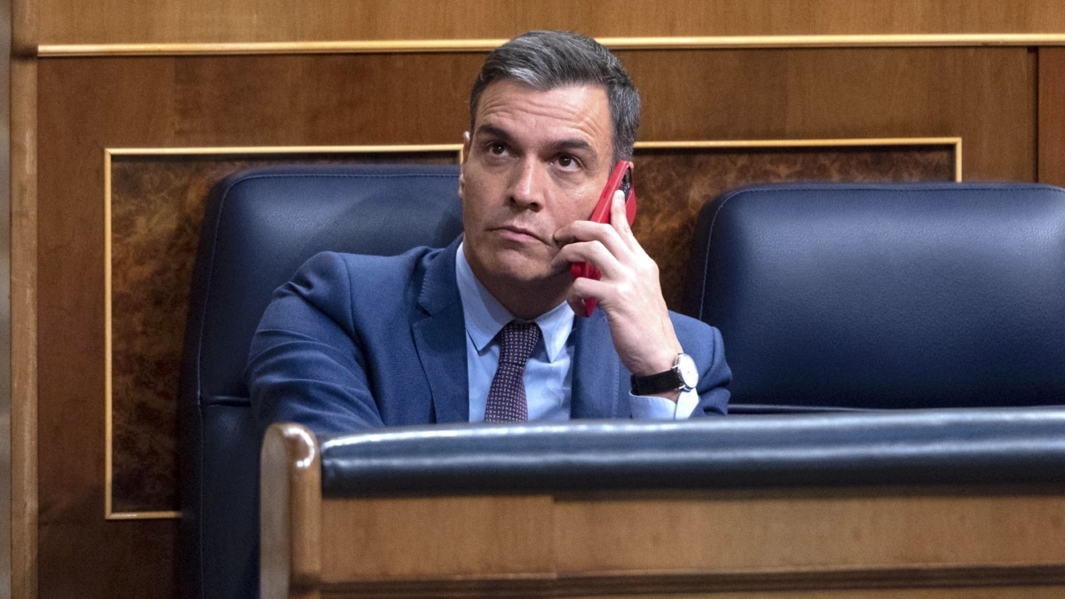 El presidente del Gobierno, Pedro Sánchez, habla por el teléfono, en una sesión extraordinaria en el Congreso de los Diputados