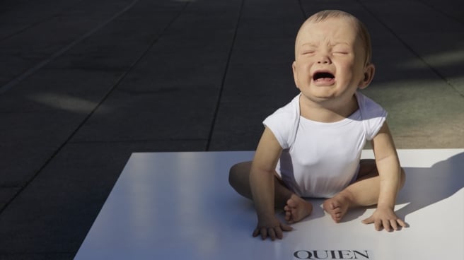 Archival photo of a sculpture of a crying child, created by artist Cristina Iglesias to demand regulation of the right to breastfeeding in public places.  Square of the Reina Sofia Museum in Madrid.