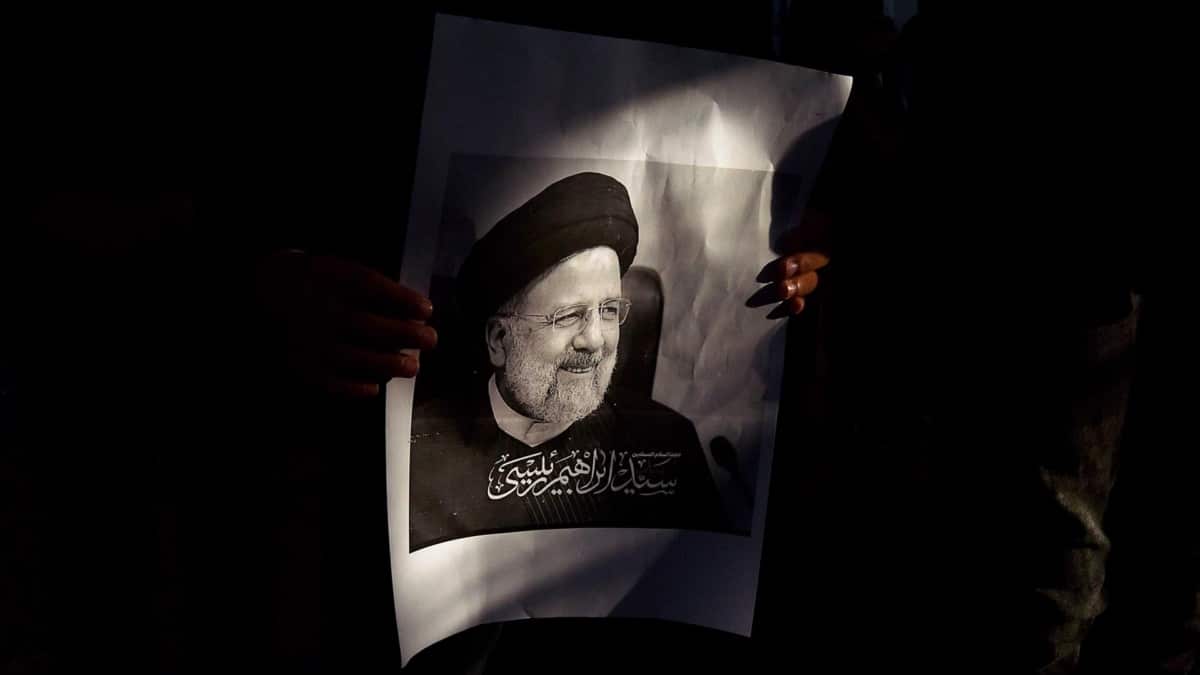 Un iraní porta una imagen del presidente Raisi.